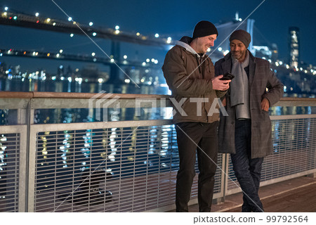 Two men at Brooklyn Bridge at night - travel photography 99792564