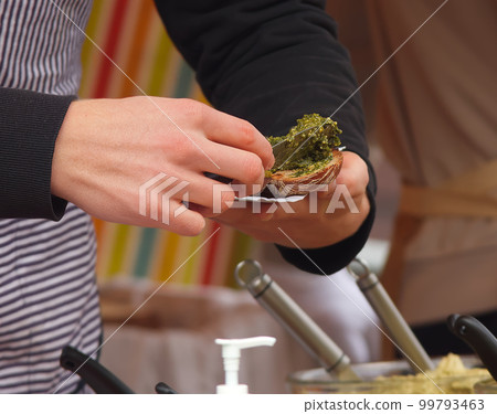 Making herb toast with green pesto at the Prague farmers market Making herb toast with green pesto at the Prague farmers market 99793463