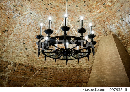 Big vintage chandelier in Interior old tower of the Turaida Castle. Brick ceiling Big vintage chandelier in Interior old tower of the Turaida Castle. Brick ceiling 99793846
