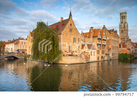 Architecture of idyllic Bruges with canal and swans floating in a row, Flanders, Belgium Architecture of idyllic Bruges with canal and swans floating in a row, Flanders, Belgium 99794757