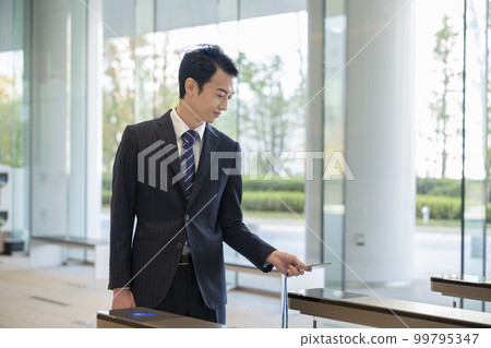 商人通過辦公樓的安全門 99795347