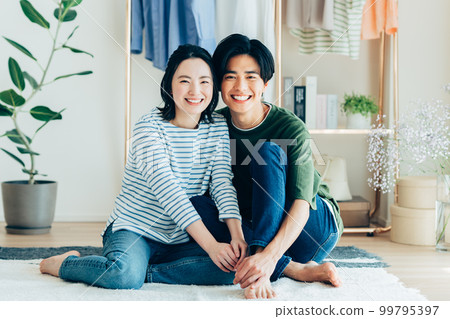 A young couple relaxing in the living room A young couple relaxing in the living room 99795397