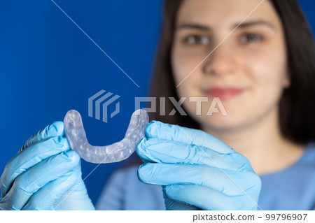Doctor holding dental mouthguard, splint for the treatment of dysfunction of the temporomandibular joints, bruxism, malocclusion, to relax the muscles of the jaw. 99796907