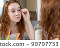 A young teenage girl washes and takes care of her face in the bathroom. High quality photo 99797733