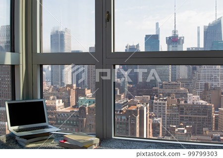 A view, a laptop and a book from an apartment in NY 99799303