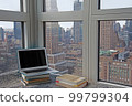 New York apartment with laptop and books and city view 99799304