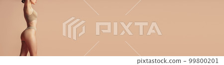 Cropped image of beautiful slender woman in underwear, lingerie posing over sand color background. Concept of beauty, body and skin care, health, spa 99800201