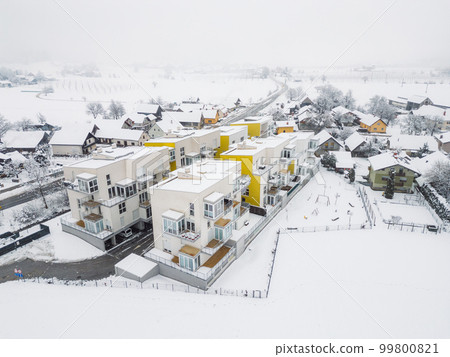 Aerial view of new modern apartment complex on a snowy day 99800821