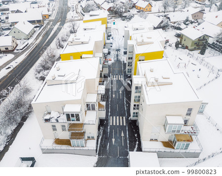 Drone flying over newly build residential buildings with apartments on a snowy winter day Drone flying over newly build residential buildings with apartments on a snowy winter day 99800823