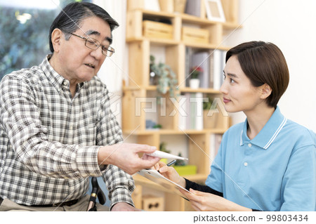 Senior man and caregiver checking physical condition 99803434