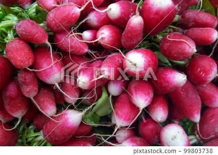 Stack of radishes on a market stall Stack of radishes on a market stall 99803738