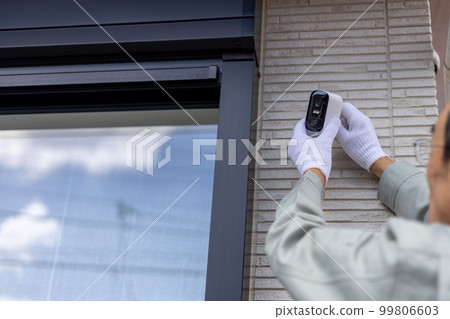 About to install a security camera on the outer wall of a detached house About to install a security camera on the outer wall of a detached house 99806603