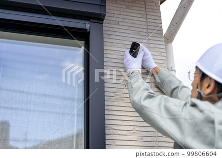 About to install a security camera on the outer wall of a detached house 99806604