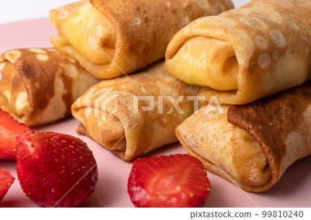 Wheat flour pancakes with strawberries. Sweet homemade pastries for breakfast. With sugar. 99810240