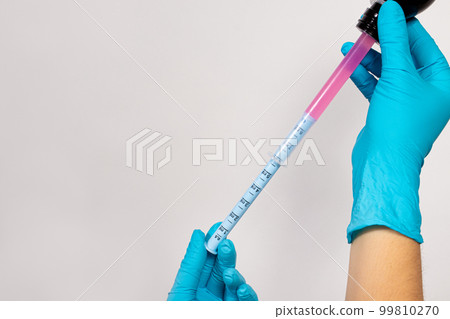 The doctor picks up from the bottle a sprinkle of cough and temperature for children in a measuring tube plastic syringe. Banner with copy space for text for pediatric clinic, pharmacy The doctor picks up from the bottle a sprinkle of cough and temperature for children in a measuring tube plastic syringe. Banner with copy space for text for pediatric clinic, pharmacy 99810270