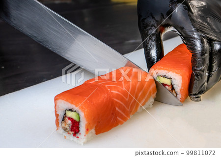 Cut the sushi into pieces. Rolls, cooking. Japanese cuisine. 99811072
