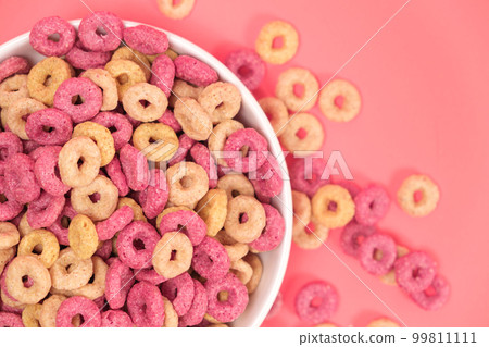 Quick cereal breakfast in the form of rings on a plate on a pink background Quick cereal breakfast in the form of rings on a plate on a pink background 99811111