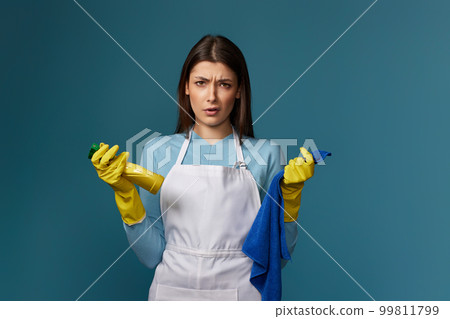 frowning woman cleaner apron with cleaning rag and detergent sprayer frowning woman cleaner apron with cleaning rag and detergent sprayer 99811799