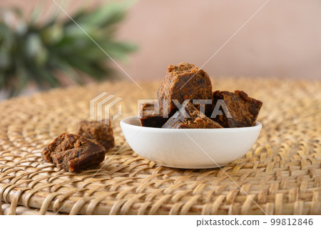 Kithul jaggery and treacle natural sweetener in white bowl. Alternative sugar and superfood. 99812846