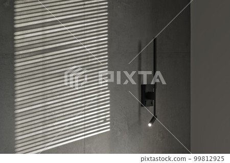 Minimalistic black wall light in modern interior in grey and black colours, concrete wall design, clay wall. Contemporary interior design aesthetics with concrete details 99812925