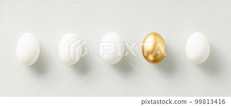 White chicken eggs with one golden egg flat lay top view banner 99813416