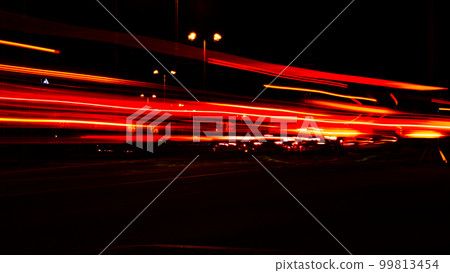 Lights of cars at night. Street line lights. Night highway city. Long exposure photograph night road. Colored bands of red light trails on the road. Background wallpaper defocused  99813454