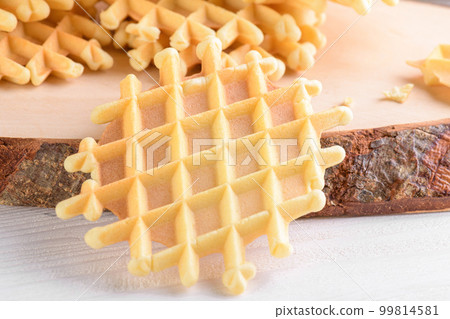 Ferratelle or pizzelle a traditional dessert or cookies from Abruzzo on a cutting board on a white wooden background 99814581