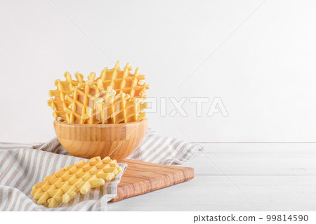 Ferratelle or pizzelle a traditional dessert or cookies from Abruzzo in a bowl on white wooden background, copy space Ferratelle or pizzelle a traditional dessert or cookies from Abruzzo in a bowl on white wooden background, copy space 99814590