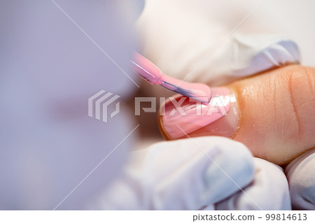 Application of hybrid varnish to the natural nail plate. Application of hybrid varnish to the natural nail plate. 99814613
