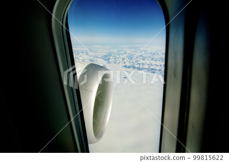 GREENLAND - 10 MAY 2018: View from the large plane window of a modern aircraft of the jet engine and the icy landscape of Greenland in the background 99815622