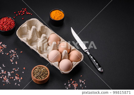 Fresh raw chicken eggs in beige color in a cardboard tray Fresh raw chicken eggs in beige color in a cardboard tray 99815871
