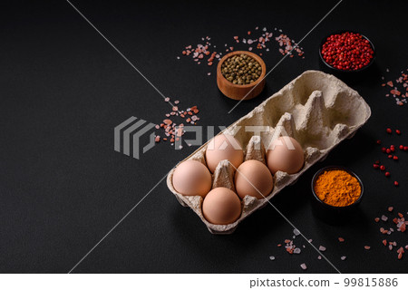 Fresh raw chicken eggs in beige color in a cardboard tray 99815886