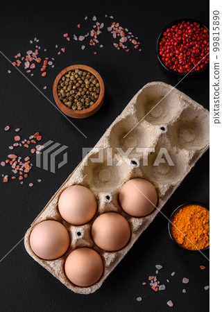 Fresh raw chicken eggs in beige color in a cardboard tray 99815890
