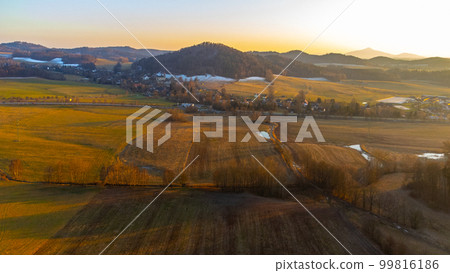 A winter landscape without snow. A clear evening during sunset over the hills of the Lusatian Mountains, Czech Republic. Aerial drone view. 99816186