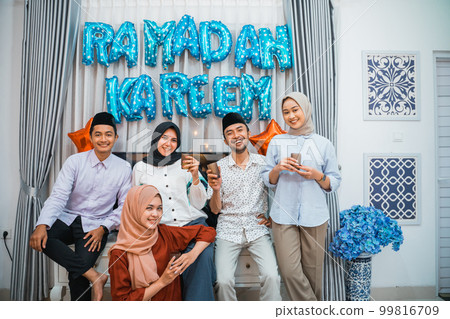 group of friends carrying drinking glasses after decorating the room 99816709