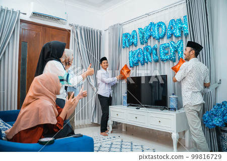 two men put up a sign for Ramadan celebration 99816729