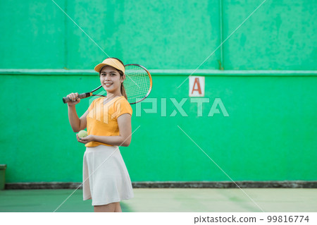 smiling tennis player carrying racket and ball 99816774