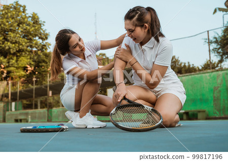 female athlete injured her arm and was helped by friend female athlete injured her arm and was helped by friend 99817196