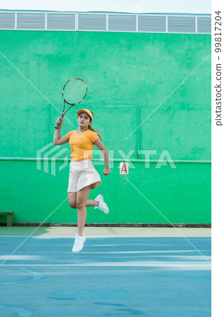 Female tennis player moving in jumping after hitting ball 99817204