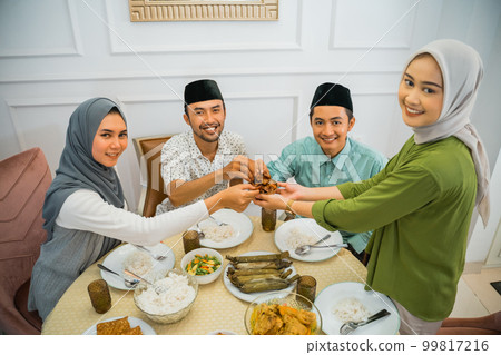 two Muslim couples picking up dates while breaking their fast two Muslim couples picking up dates while breaking their fast 99817216