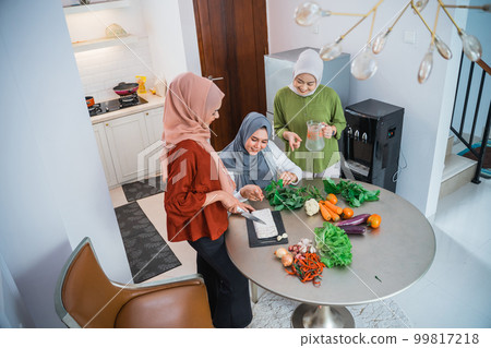 muslim woman cooking for dinner at friends home during ramadan 99817218