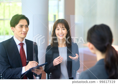 Male and female business people interviewing at a venue with measures against infectious diseases 99817319