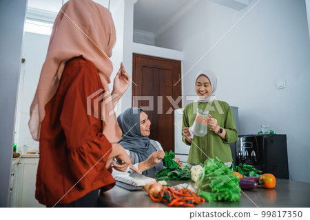 muslim woman cooking for dinner at friends home during ramadan muslim woman cooking for dinner at friends home during ramadan 99817350
