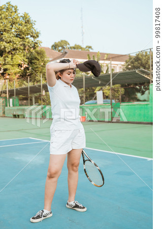 Tennis athletes take off their hats when they are tired 99817408