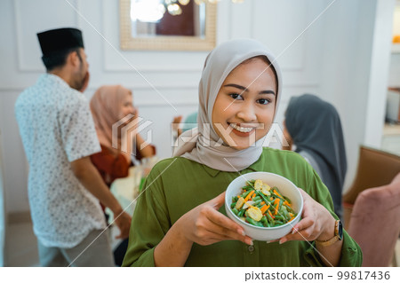 muslim woman with food served for family and friend for dinner muslim woman with food served for family and friend for dinner 99817436