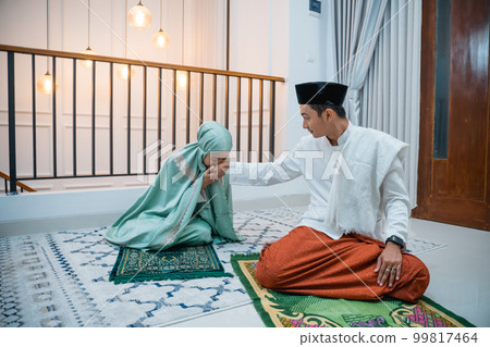 woman kisses man's hand as prayer leader after praying woman kisses man's hand as prayer leader after praying 99817464