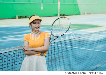 female tennis player smiling at camera with crossed hands female tennis player smiling at camera with crossed hands 99817467