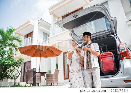 Asian Muslim couple using smartphone together after preparing in car Asian Muslim couple using smartphone together after preparing in car 99817484