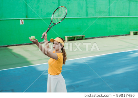 female tennis player will serve holding the ball with racket female tennis player will serve holding the ball with racket 99817486