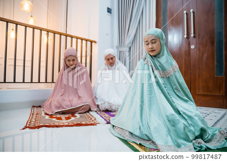 Asian Muslim women wearing Muslim clothes doing Salam movement Asian Muslim women wearing Muslim clothes doing Salam movement 99817487
